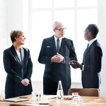 Three people in board room discussion